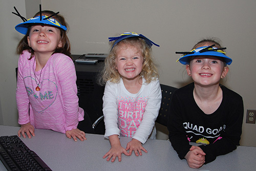 Three smiling girls with silly visors